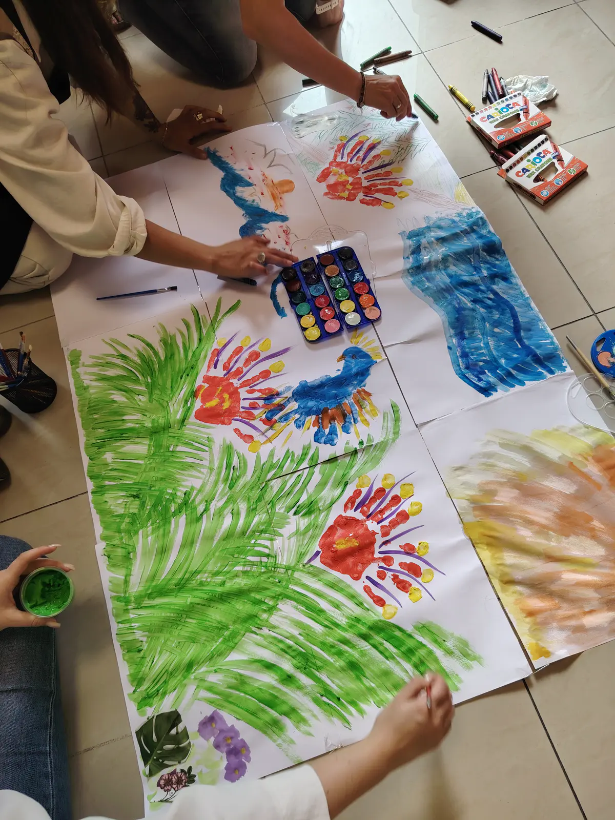 Group painting with handprints during an art for wellbeing session