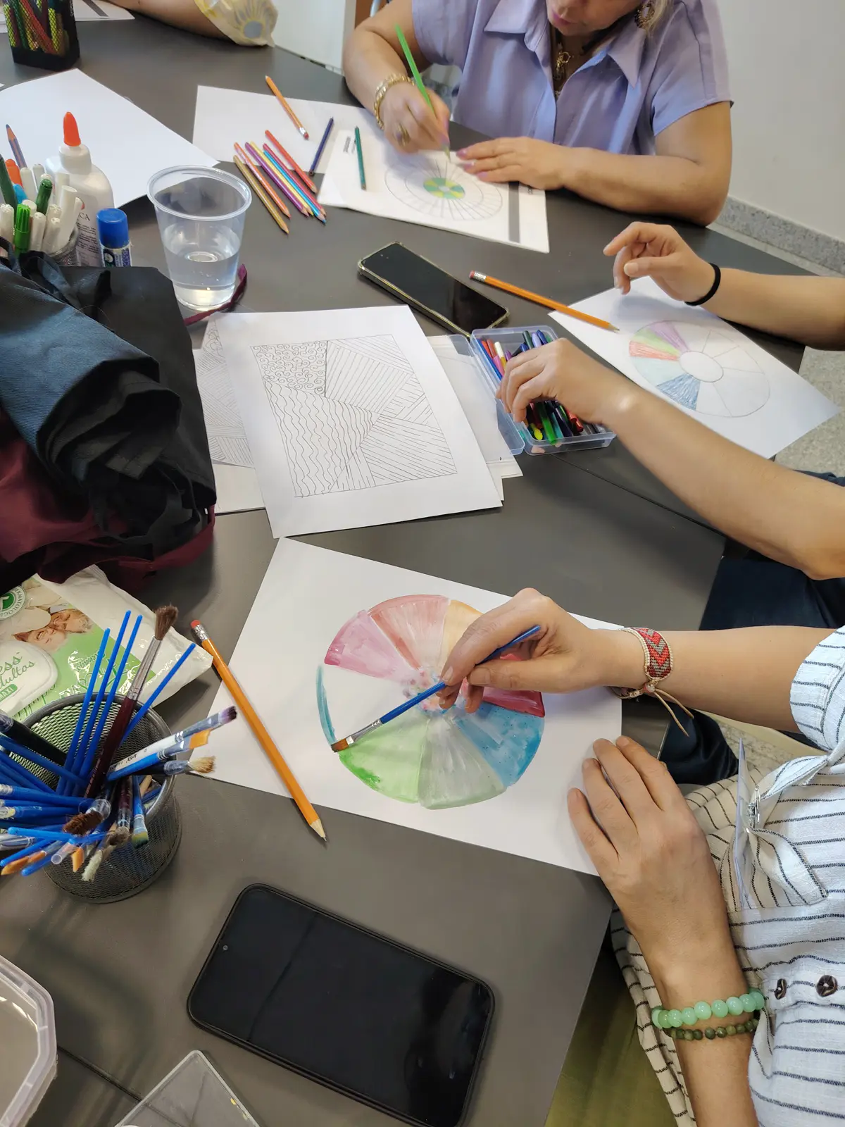 Clients painting colour wheels during a creative coaching session